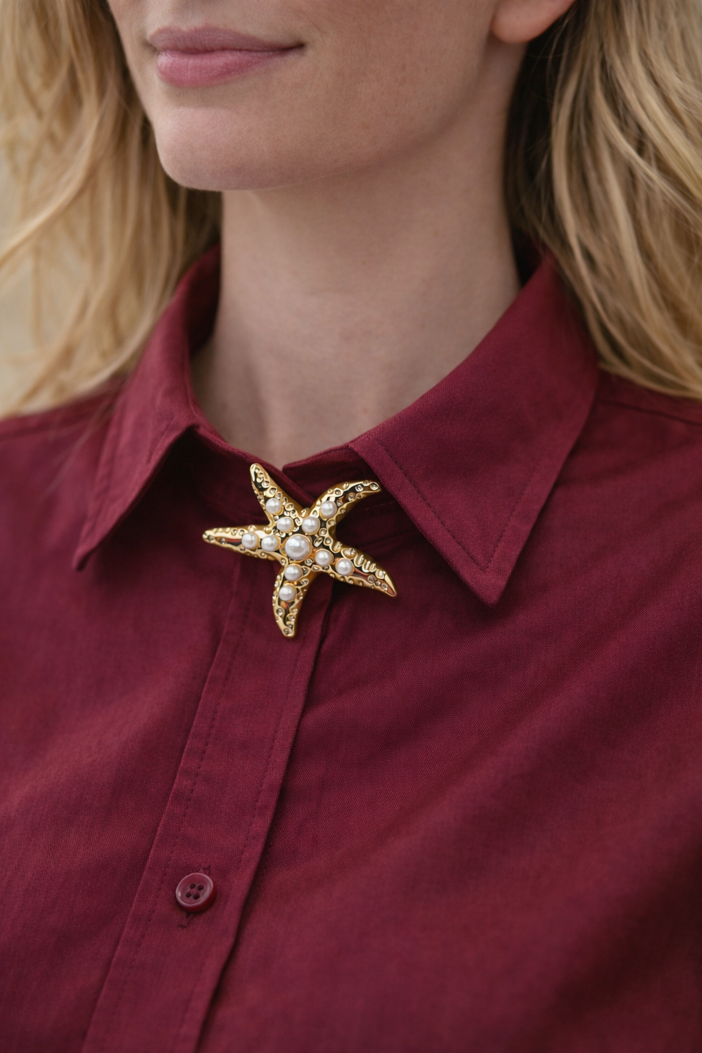 Starfish-shaped brooch on a red shirt worn by a person