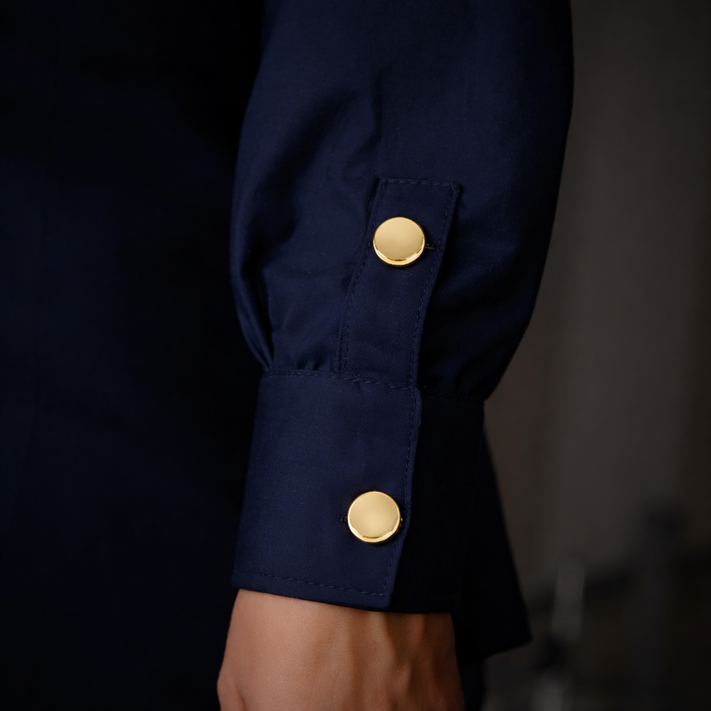 Navy blue sleeve with gold buttons on a dark background