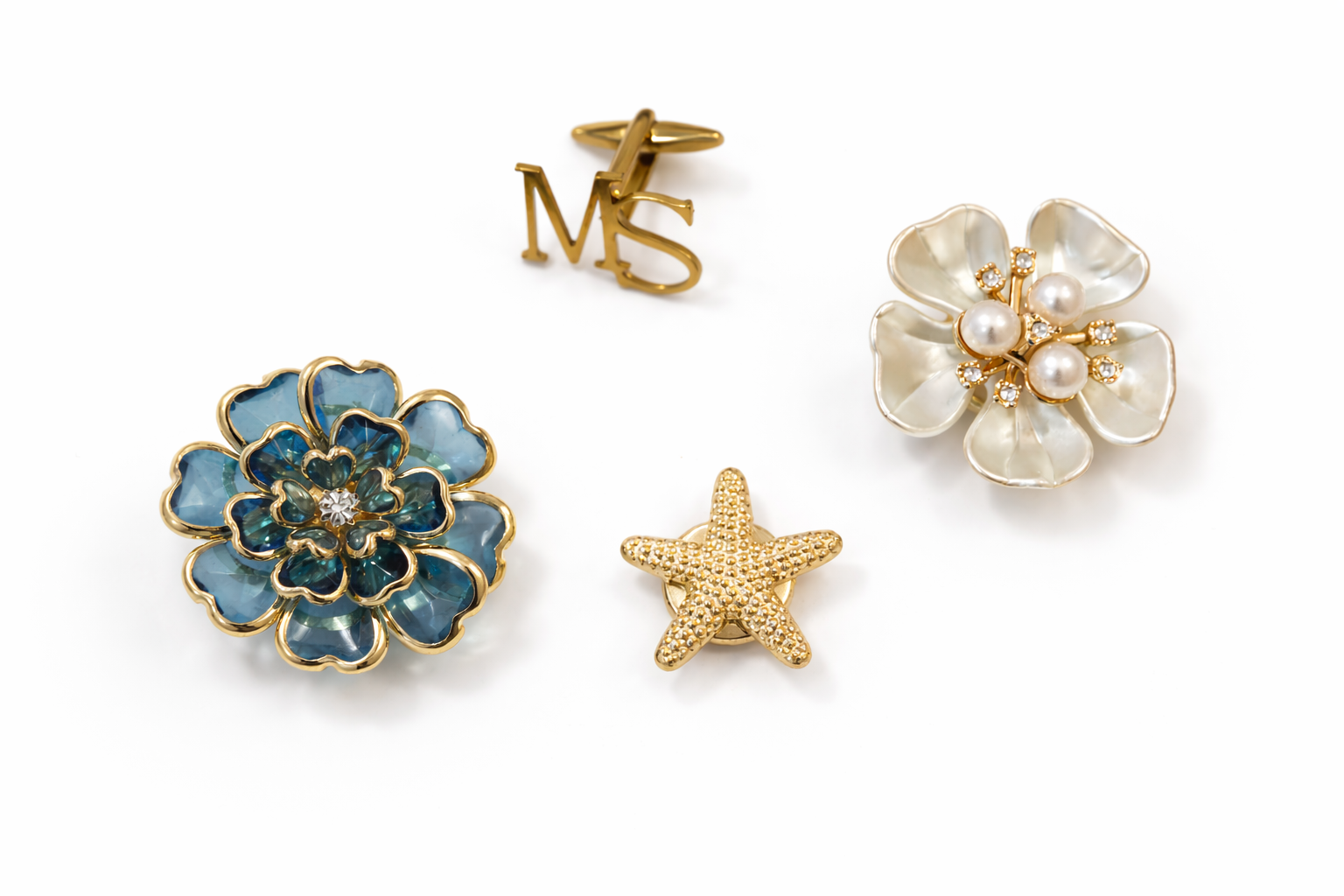 Set of four floral and starfish-shaped jewelry pieces on a white background